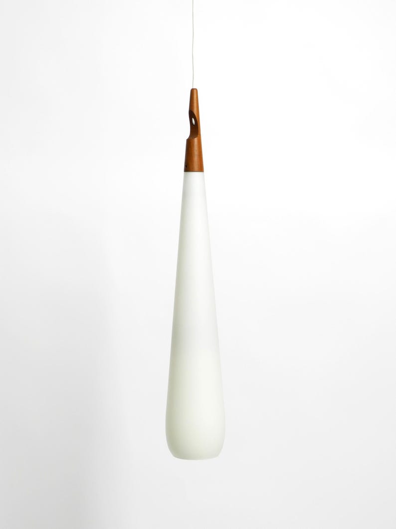 May include: A white teardrop-shaped glass pendant light with a wooden top.