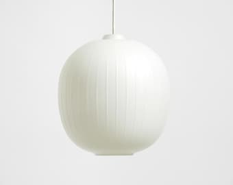 Puede incluir: Lámpara colgante ovalada blanca con líneas verticales texturizadas. Cuelga de un fino cable blanco. El diseño minimalista es adecuado para interiores modernos. Aproximadamente 30 cm de diámetro.