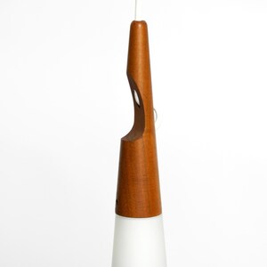 May include: A mid-century modern pendant light with a white frosted glass shade and a natural wood base.