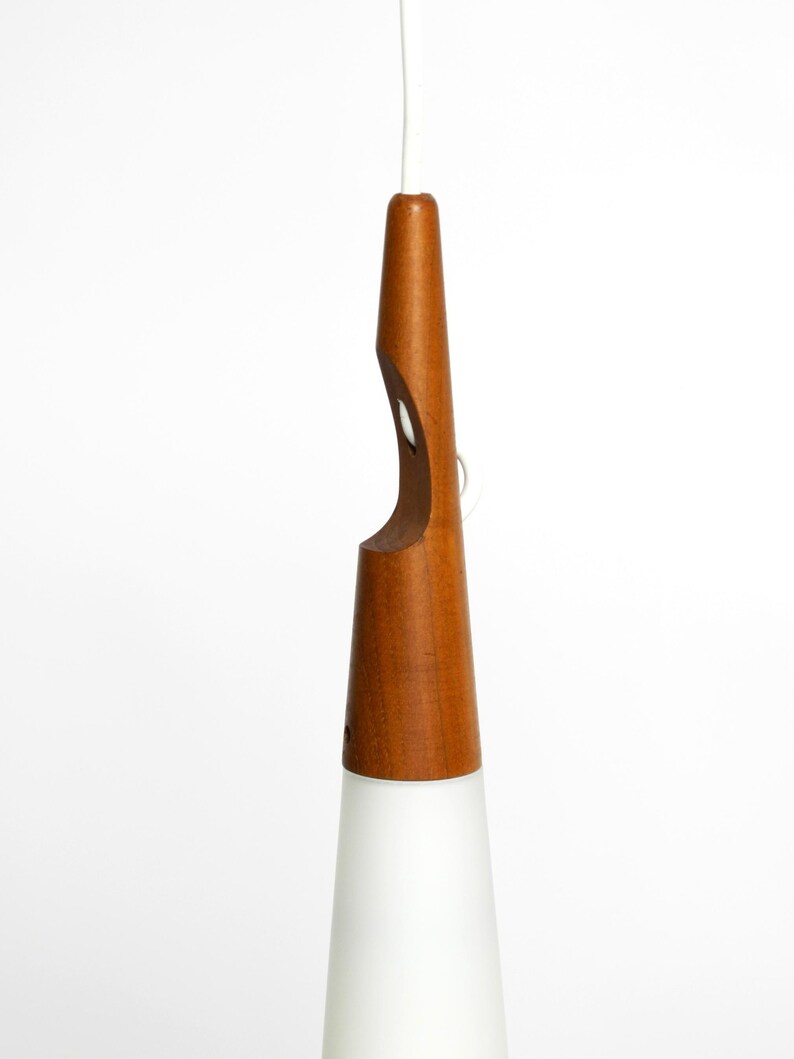 May include: A mid-century modern pendant light with a white frosted glass shade and a natural wood base.