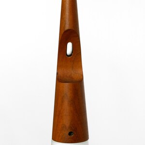 May include: A wooden pendant light with a white glass shade. The wood is a rich brown color and the shade is a simple, conical shape.