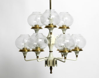 May include: A white and gold chandelier with eight frosted glass globes. The chandelier has a modern design with a central stem and curved arms.