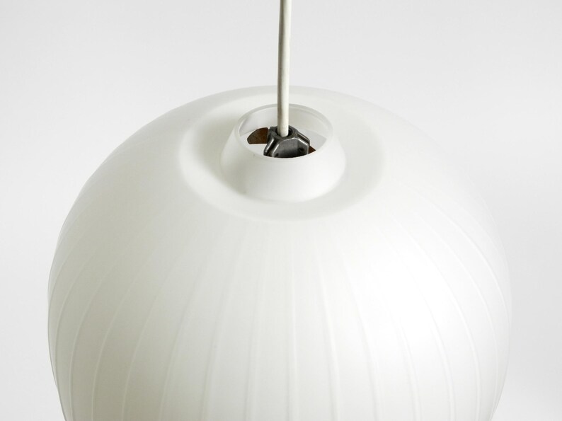 Puede incluir: Una l&aacute;mpara colgante esf&eacute;rica blanca con detalles acanalados verticales. La luz cuelga de un cable blanco y tiene una parte superior circular. El accesorio es un dise&ntilde;o moderno, adecuado para la iluminaci&oacute;n interior.