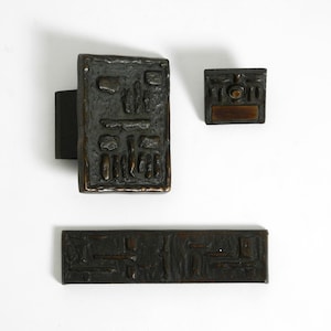 Puede incluir: Un juego de tres tazas de cerámica con un acabado moteado y mate. Las tazas son de color crema, gris claro y gris oscuro. Cada taza tiene un diseño simple y minimalista.