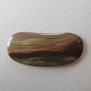 May include: A polished, oval-shaped gemstone with a layered pattern of brown, tan, and green hues. The stone has a glossy finish and a smooth, rounded shape. The colors blend together, creating a natural, earthy aesthetic.