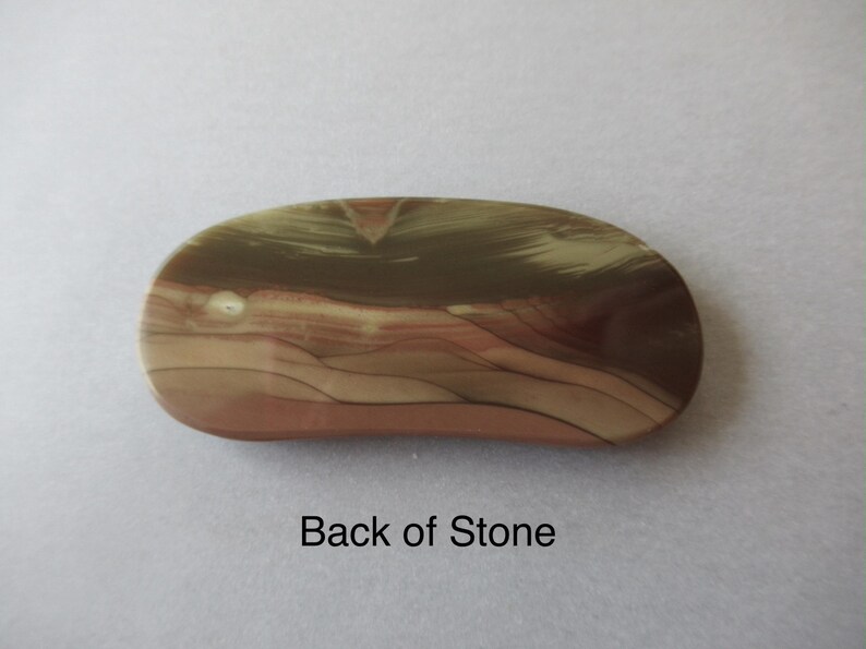 May include: An oval-shaped stone with a polished surface. The stone features a blend of colors, including tan, brown, and reddish-brown hues, with a layered pattern. The text "Back of Stone" is visible.