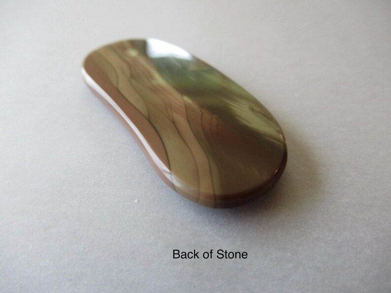 May include: A polished, oval-shaped stone with a smooth, glossy surface. The stone features a blend of brown, tan, and cream colors with a wavy pattern. The text "Back of Stone" is visible.