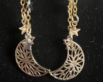 May include: Gold tone earrings with a crescent moon and star charms hanging from a chain. The moon charms are filigree and the stars are solid.