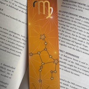 May include: A gold bookmark with a Virgo zodiac symbol and stars on a yellow background. The bookmark has text on the back, including "Royal Lyceum Theatre, London" and "Gillespie Crescent, Bruntsfield".