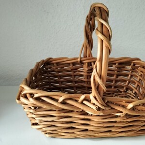 Peut inclure: Un panier en osier tressé avec une poignée. Le panier est de couleur brun clair et a une forme rectangulaire.