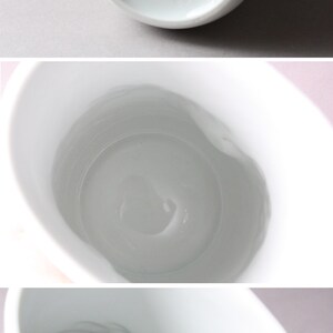 May include: White ceramic vase with a smooth, rounded shape. The bottom of the vase has the text "Thomas Germany" printed in green.