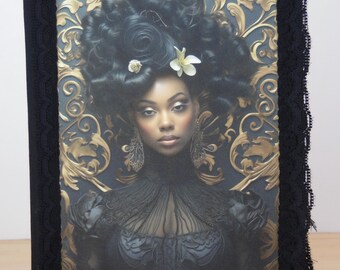 May include: A black journal with a lace trim and a gold and black patterned image of a woman with a large afro hairstyle and flowers in her hair.