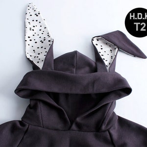 May include: A dark grey hooded sweatshirt with black and white polka dot bunny ears. The ears are sewn onto the hood. The sweatshirt has a H.D.K T2 label.