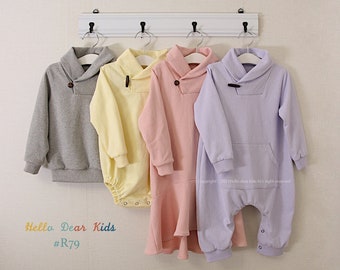 May include: Four children's outfits in gray, yellow, pink, and lavender, each with a unique design. The outfits include a sweatshirt, a romper, and a dress, all with a shawl collar and a button closure. The text "Hello Dear Kids #R79" is visible.
