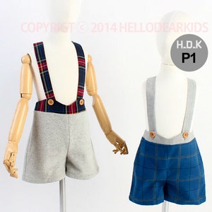 May include: Two pairs of toddler shorts with braces. One pair is grey with red and blue plaid braces. The other pair is blue with a plaid pattern and grey braces. The text "H.D.K P1" is on a grey tag.