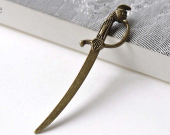 May include: A bronze-colored sword bookmark with a detailed handle and a sharp point.