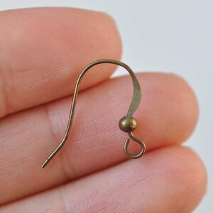 May include: A gold-toned earring hook with a small ball at the end.