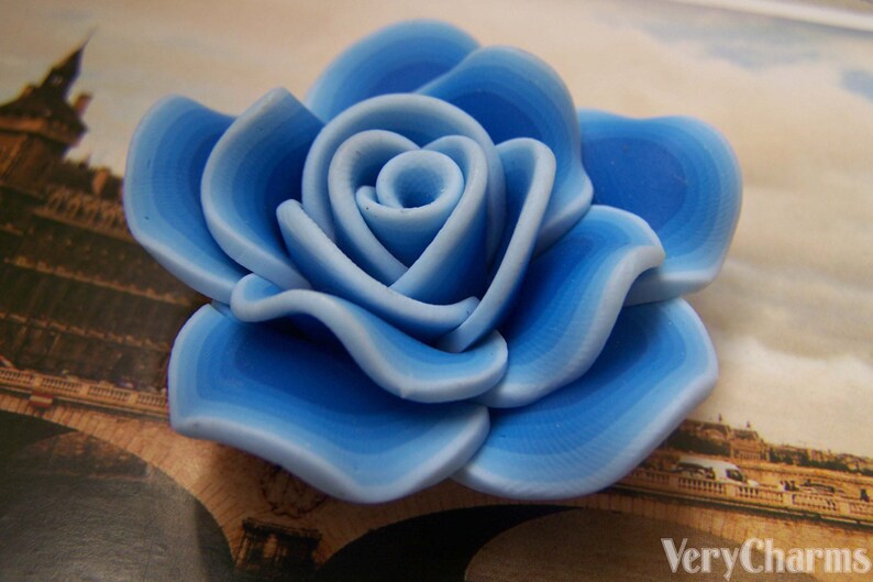Peut inclure: Une rose en c&eacute;ramique bleue et blanche avec un design en couches. La rose est un accent d&eacute;coratif pour une maison ou un bureau.