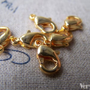 以下が含まれることがあります： 金色の金属製のロブスタークロウクラスプ5個。ジュエリー作りのための留め具の一種です。