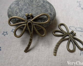 May include: Two antique bronze dragonfly charms with intricate wire designs. The charms are about 2 inches long and have a detailed body and wings.