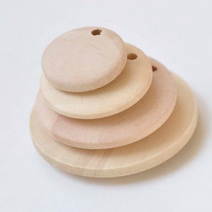 以下が含まれることがあります： 4つの未完成の木製円が積み重ねられています。円の中央には穴があり、サイズはそれぞれ異なります。