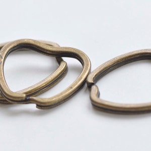 Può includere: Quattro portachiavi a forma di cuore in oro antico.