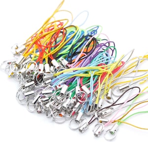 Puede incluir: Un gran surtido de llaveros de cuerda de colores con cierres de metal plateado. Los llaveros están hechos de cuerda de diferentes colores, incluyendo rojo, amarillo, azul, verde y morado.