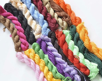 May include: A collection of 20 spools of colorful embroidery floss, arranged in a fan shape. The floss is made of cotton and is available in a variety of colors, including red, orange, yellow, green, blue, purple, pink, and brown.