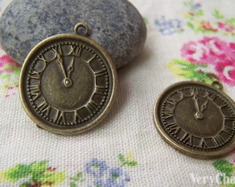 May include: Two antique gold-toned clock face charms with Roman numeral markings. The charms have a loop at the top for attaching to jewelry or other crafts.