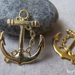 May include: Two gold-tone metal anchor charms featuring a chain detail. The anchors are a popular nautical theme for jewellery making.