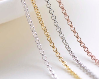 May include: Four chains of different colors: silver, gold, rose gold, and white gold. The chains are laid out in a row on a white surface.