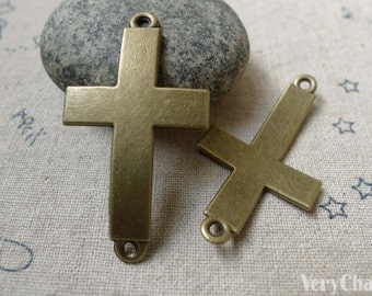 Puede incluir: Dos abalorios de cruz de metal de color dorado antiguo con acabado cepillado. La cruz más grande mide aproximadamente 5 cm de alto y la cruz más pequeña mide aproximadamente 3,8 cm de alto. Ambas cruces tienen un bucle en la parte superior para colgar.