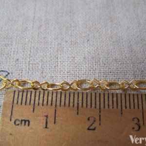 May include: Gold chain with oval links, measuring 4 cm in length. The chain is shown next to a ruler.