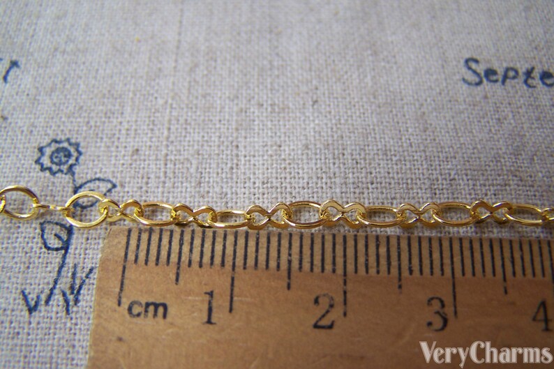 May include: Gold chain with oval links, measuring 4 cm in length. The chain is shown next to a ruler.
