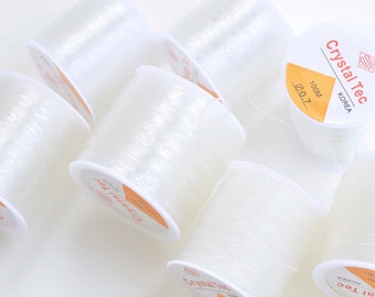 May include: Six spools of clear elastic thread, each labeled "Crystal Tec Korea 100M 0.7".