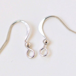 May include: Two silver earring hooks with a small ball at the top of the hook.
