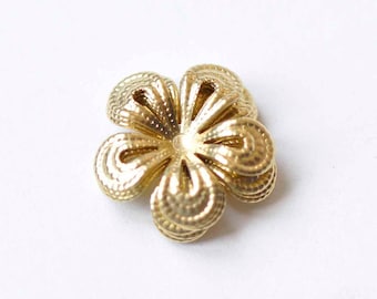 May include: A gold-colored metal flower-shaped embellishment with a textured surface.