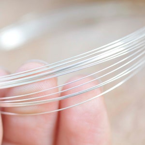 Puede incluir: Primer plano de un haz de alambre de plata, mostrando la superficie lisa y brillante del alambre.