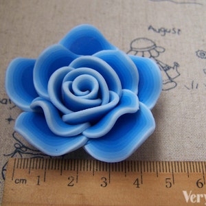 Peut inclure: Une rose en p&acirc;te polym&egrave;re bleu clair avec un design en couches. La rose mesure environ 4 cm de diam&egrave;tre.