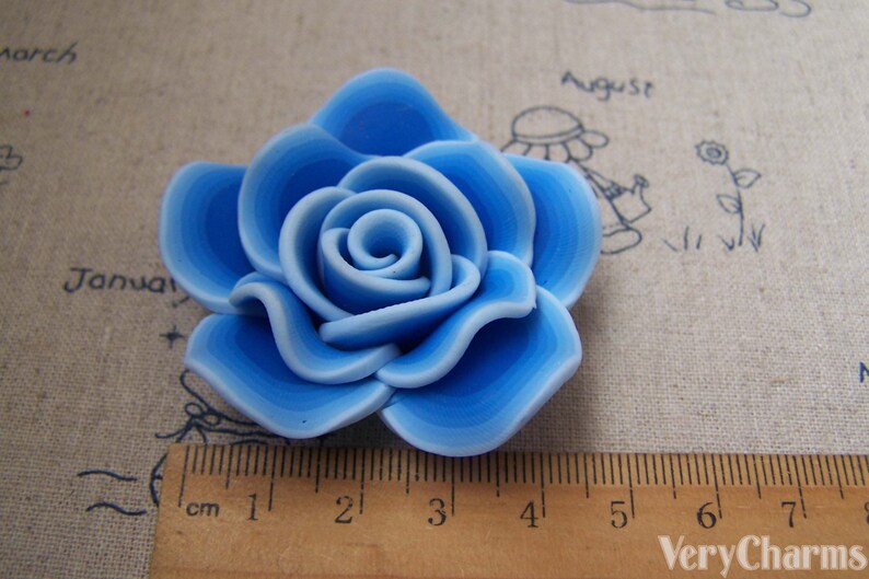 Peut inclure: Une rose en p&acirc;te polym&egrave;re bleu clair avec un design en couches. La rose mesure environ 4 cm de diam&egrave;tre.