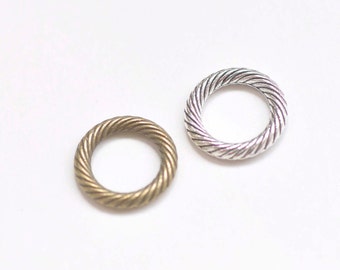 May include: Two metal rings with a twisted rope design. One ring is silver and the other is bronze.