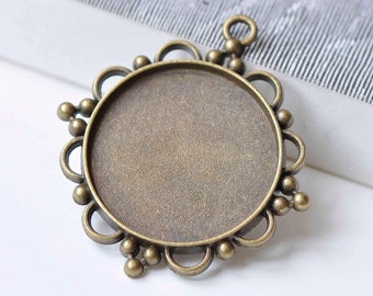 May include: A bronze pendant with a round, open bezel and a decorative border of small beads and loops. The pendant has a loop at the top for attaching a chain or cord.