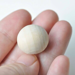 Puede incluir: Primer plano de una bola redonda de madera lisa. La bola es de color marr&oacute;n claro y tiene una superficie ligeramente texturizada.