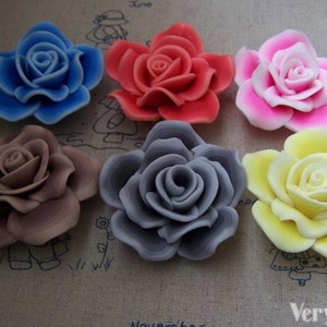 Peut inclure: Six roses en tissu de diff&eacute;rentes couleurs. Les roses sont dans des tons de bleu, rouge, rose, marron, gris et jaune.
