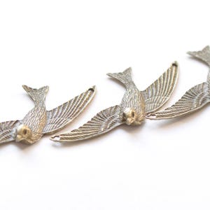 10 colgantes de bronce antiguo con forma de golondrina o paloma, con dos argollas, 38 x 72 mm.