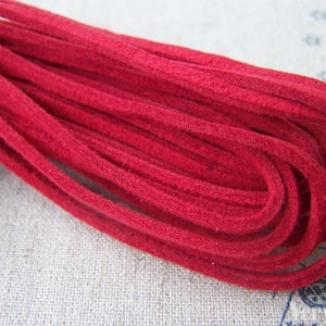 May include: A spool of red suede cord, a type of leather cord, for crafting projects.