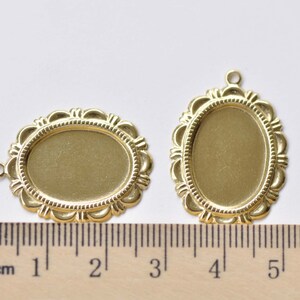 Peut inclure: Deux cadres ovales en m&eacute;tal de couleur dor&eacute;e avec des bords d&eacute;coratifs. Les cadres mesurent environ 5 cm et 10 cm de long. Une r&egrave;gle est visible pour l'&eacute;chelle.