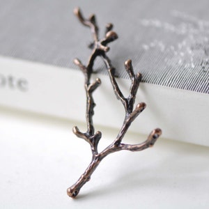 May include: A pair of copper-colored metal branches with a twig-like design. The branches are intertwined and have a rustic, natural look.