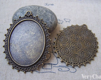 Puede incluir: Dos bandejas colgantes de metal bronce antiguo. Una es de forma ovalada con un borde decorativo y la otra es redonda con un patrón de espiral.