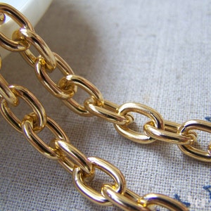 May include: Gold chain with oval links. The chain is thick and has a shiny finish.